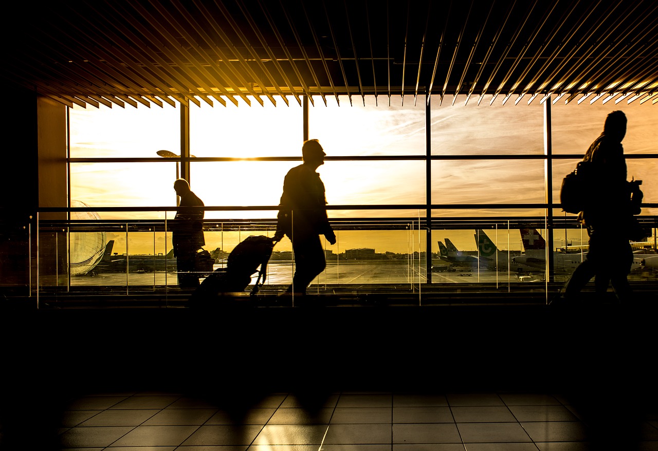 This photo is of a traveler at an airport with a suitcase to accompany the story on bleisure travel.